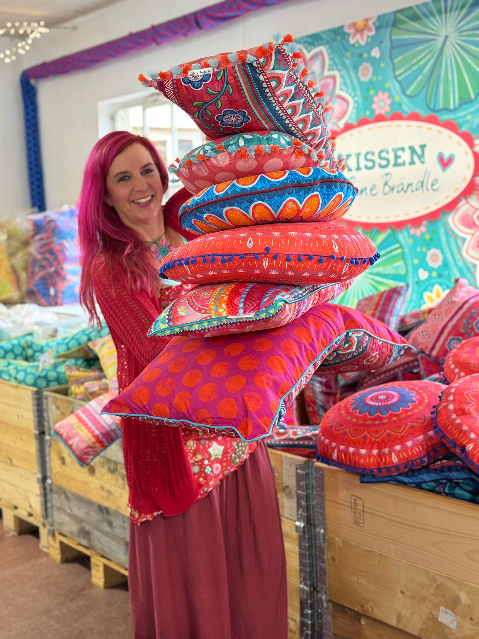 Bine Brändle hält einen Berg aus Kissen in die Kamera 